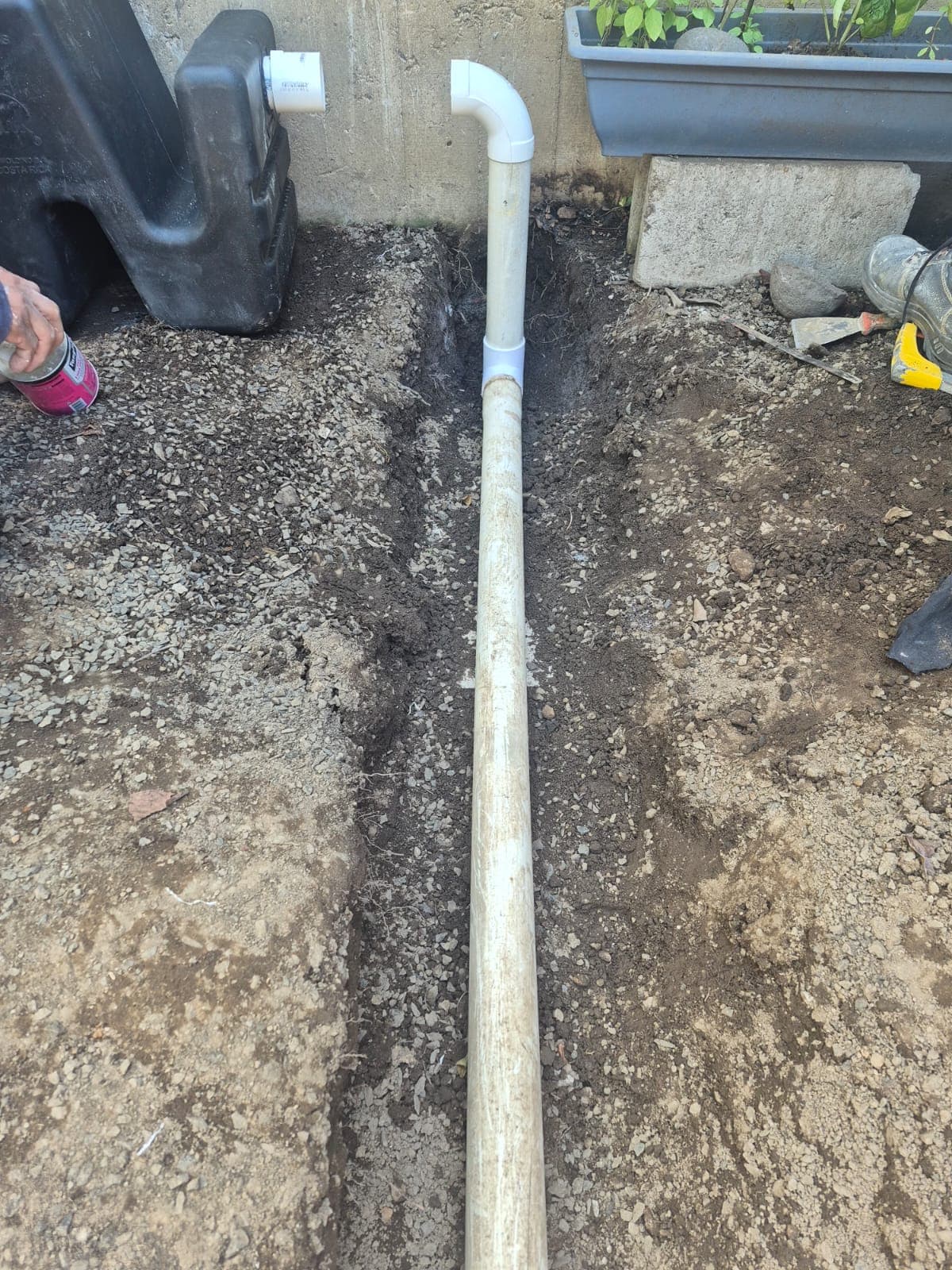 Instalación de tubería PVC de drenaje junto a muro exterior.